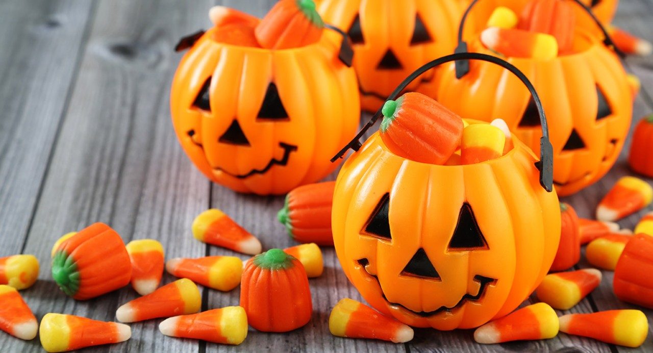 Plastic orange pumpkin baskets carry Halloween candy