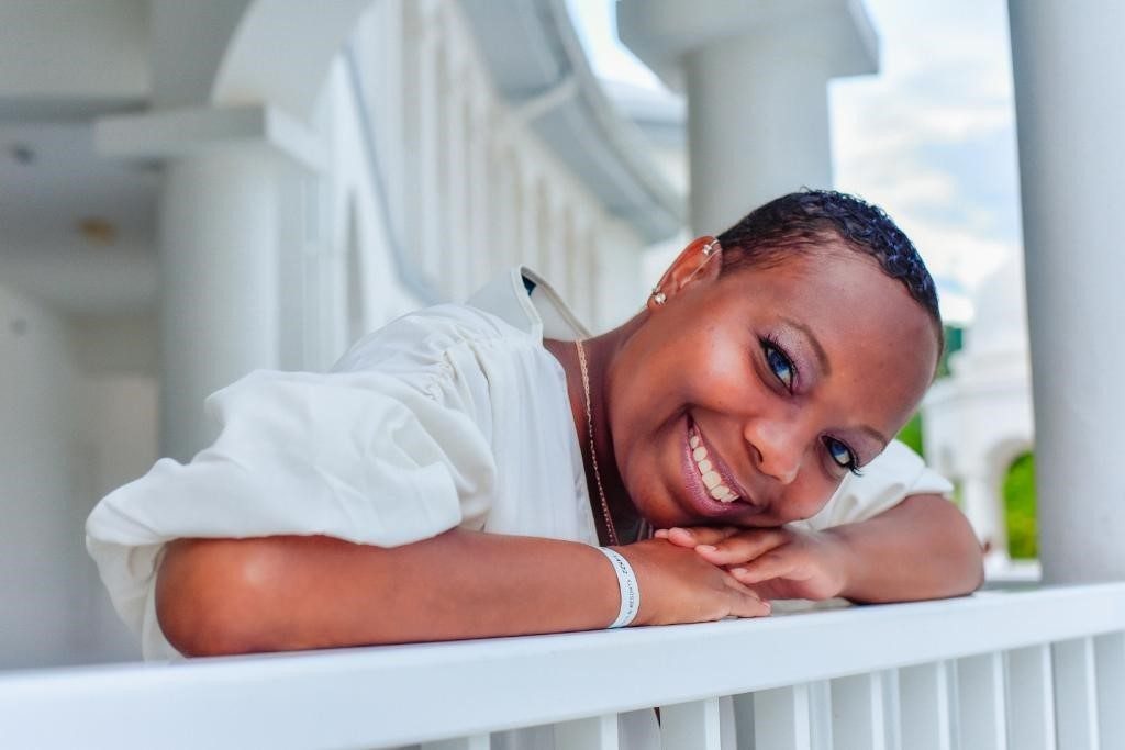Feyama Ashby leaning on a patio railing.