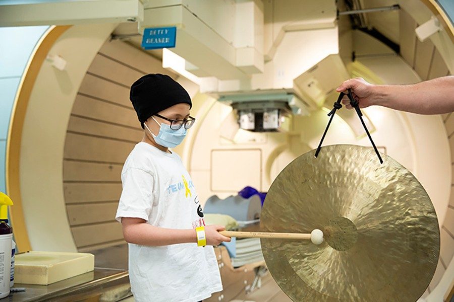 Logan Pena ringing the gong at this last proton therapy treatment at the MD Anderson Proton Therapy Center.