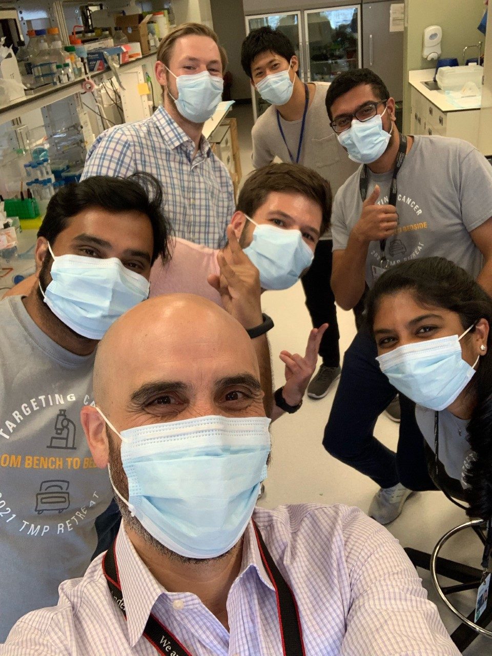Masked lab members pose for a selfie