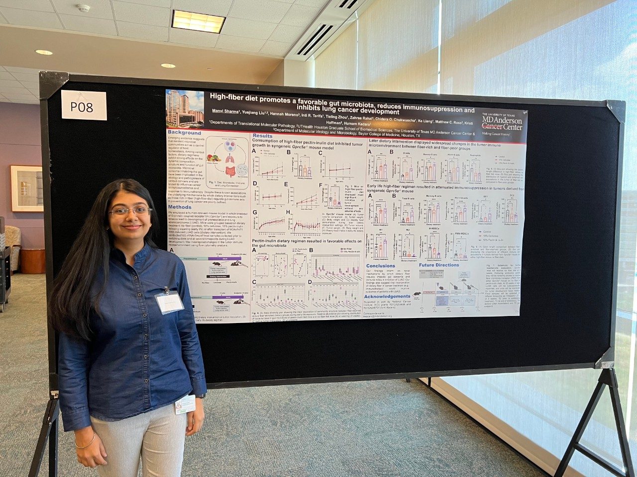A lab member standing in front of their poster